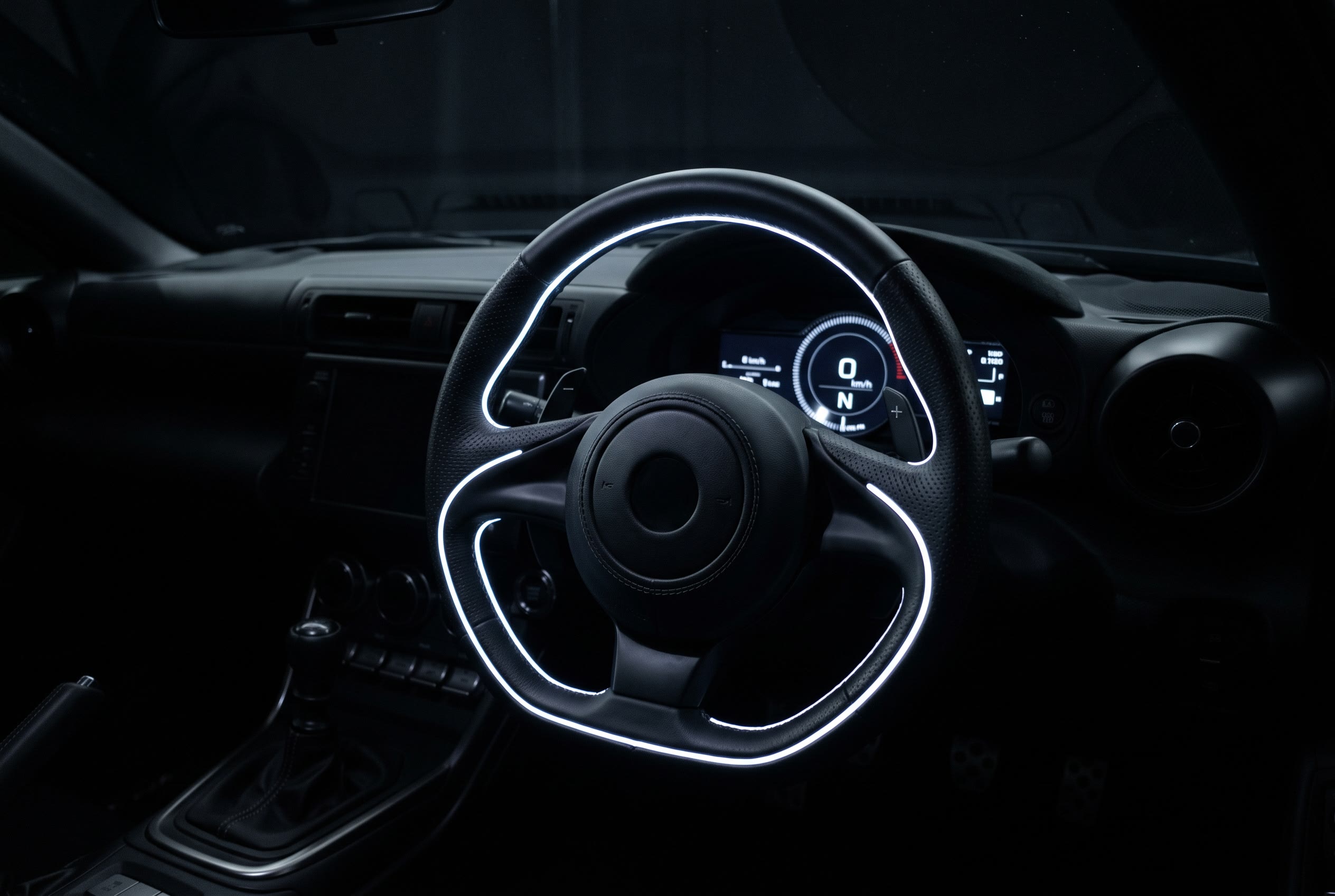 Illuminated steering wheel and dashboard in a dark car interior